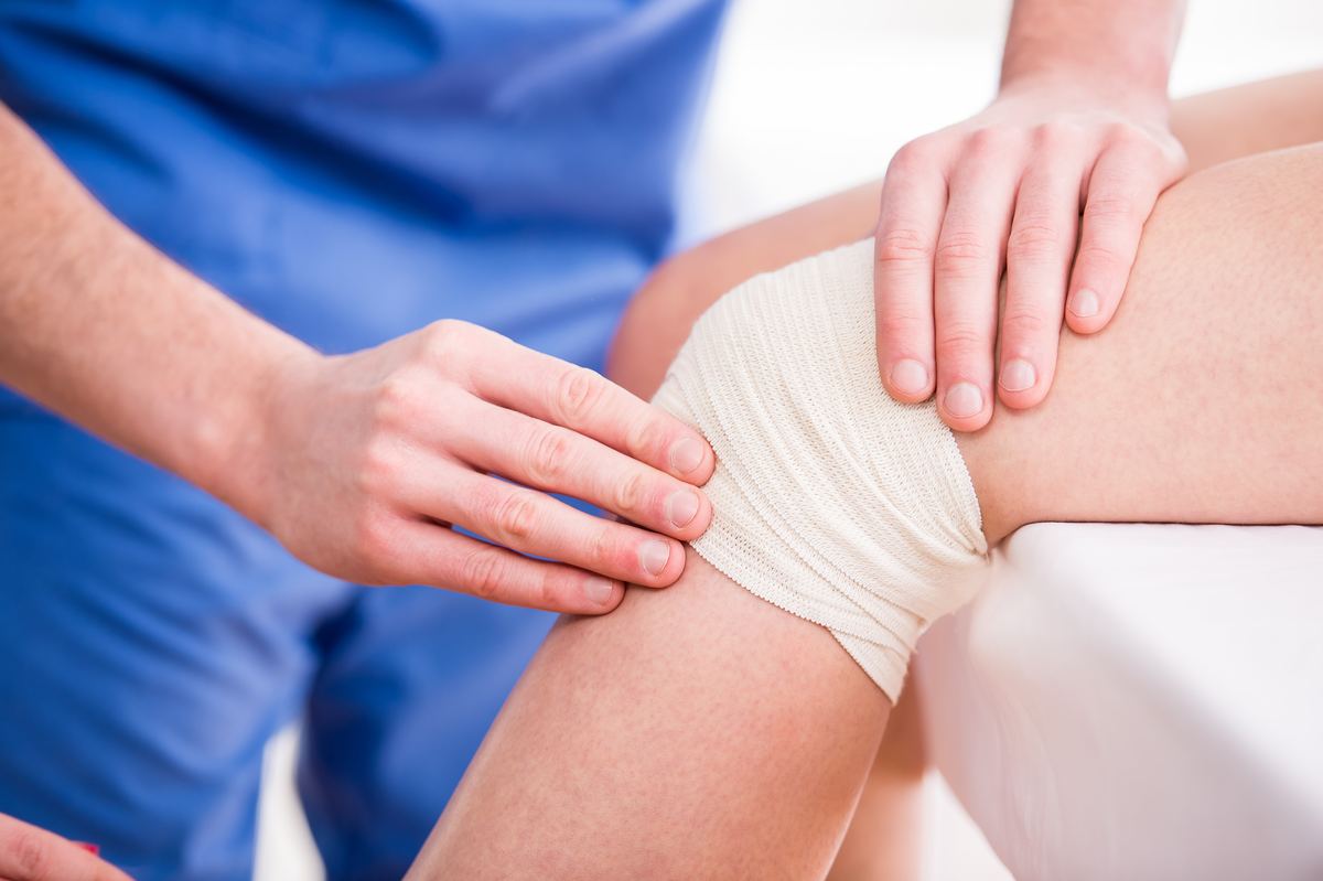doctor-is-rewinding-knee-bandage-young-woman.jpg
